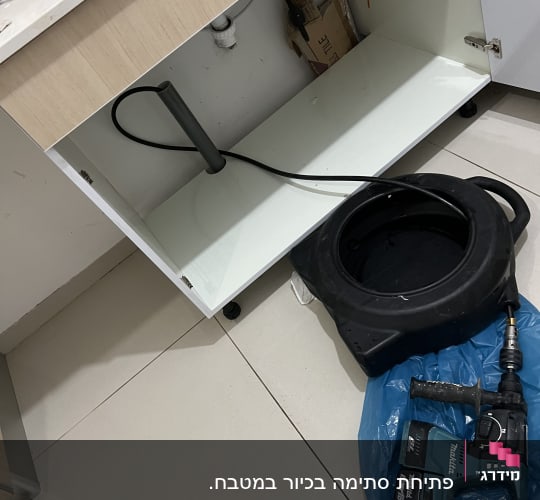 כלי עבודה של אינסטלטור מתחת לכיור במטבח